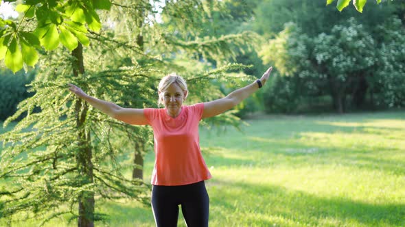 Mature Woman Doing Sports Outdoors on a Sunny Summer Day in Park