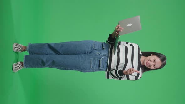 Full Body Of A Smiling Woman Showing Thumbs Up Gesture In The Green Screen Studio