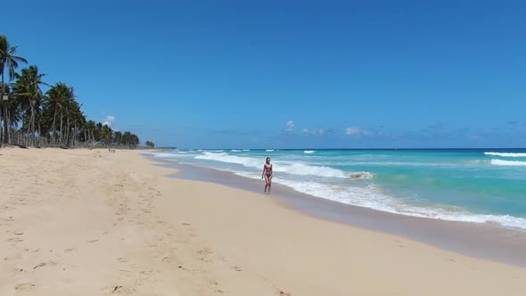 Tropical Vacation Young Woman is Walking Along the Beach and Posing Ocean