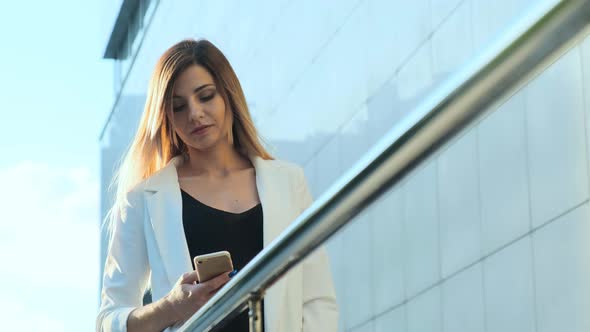 Beautiful Business Lady Is Reading a Message in a Smartphone.