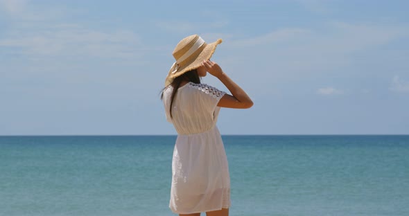 Woman with straw hat look at the sea
