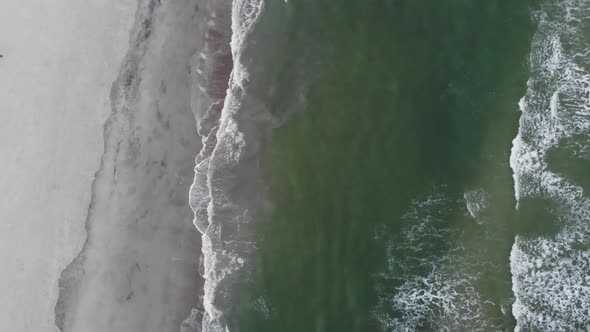 beach waves crashing shore line coast sand tide pool aerial drone