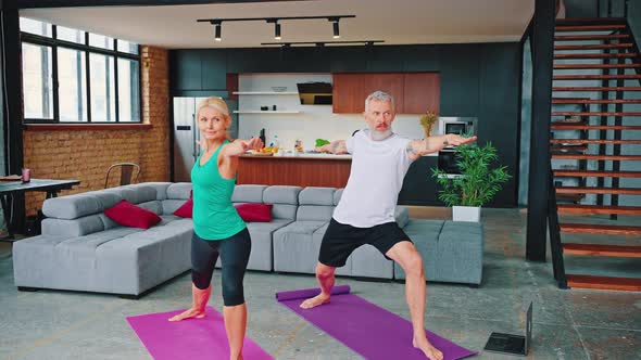 Mature Couple Practicing Yoga on Fitness Mats in Living Room