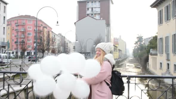 Young beautiful blonde woman playing with balloons