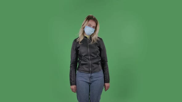 Portrait of Beautiful Young Upset Woman in Medical Protective Face Mask Is Looking at Camera