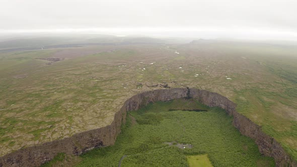 Aerial View Of Asbyrgi Glacial Canyon With Light Fog In The Horizon In Iceland.