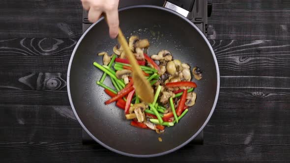 Vegetables with Peppers and Garlic Sprouts Are Fried in A Wok Pan.