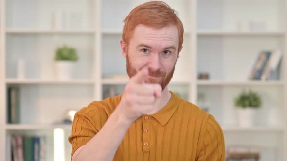 Portrait of Smiling Redhead Man Pointing at Camera