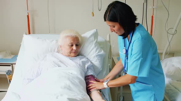 Female doctor checking blood pressure of patient