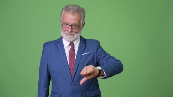 Handsome Senior Bearded Businessman Against Green Background