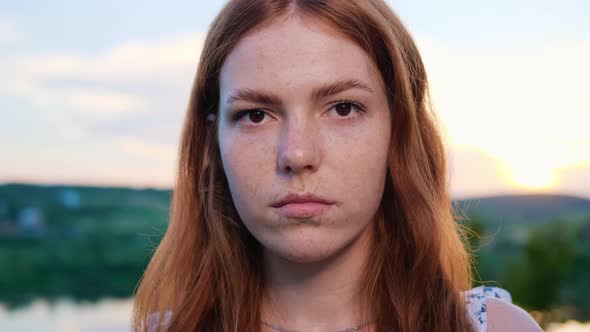 Dreamer Face Beautiful Red Haired Young Girl Posing on Background of the Lake