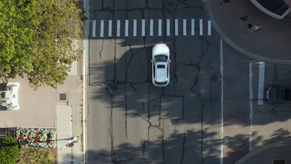 Aerial top down drone view of a city road. cars are running on city streets. Many homes and houses i