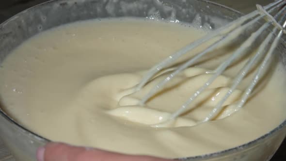 Professional Cook Hand Holds Metal Whisk and Mixes Dough