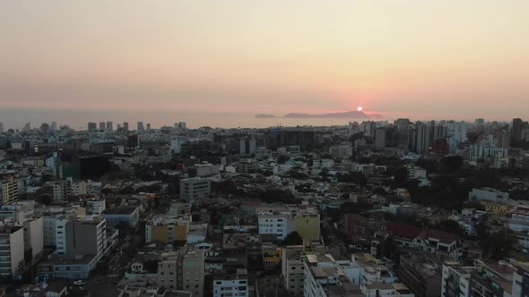 4k aerial bird's eye view over the skyscrapers of the Lima metropolis in Peru at twilight. The city