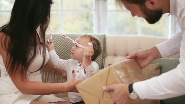 Blonde Cute Toddler Receiving Christmas Present From His Father