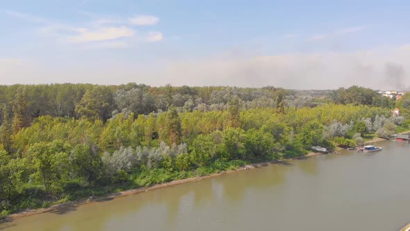 Slow motion aerial footage of forest by the river.