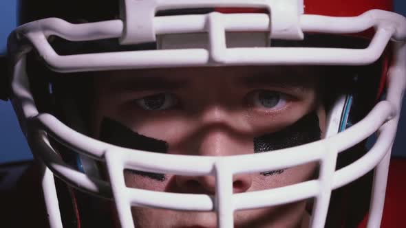 Portrait of Serious Professional American Football Player in Helmet in Bright Stadium Illumination