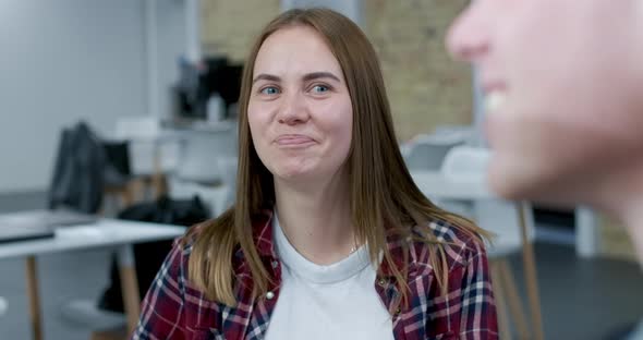 Joyful Millennial Caucasian Woman Laughing Out Loud Chatting with Colleagues in Office. Portrait of