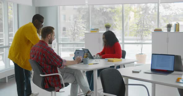 Young Modern Colleagues in Casual Wear Working Spending Time in Open Space Office