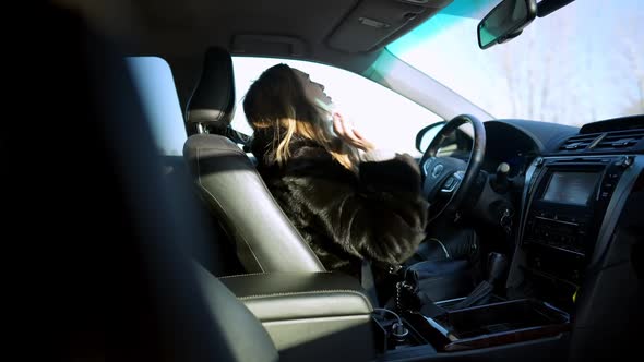 Side View of Angry Depressed Caucasian Young Woman Kicking Steering Wheel in Slow Motion and Crying