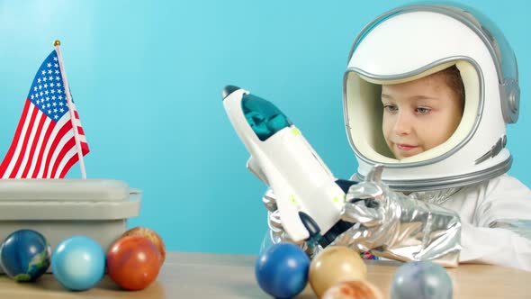 Portrait of a Child Playing at Home in an Astronaut Little Girl 89 Years Old in an Astronaut Costume