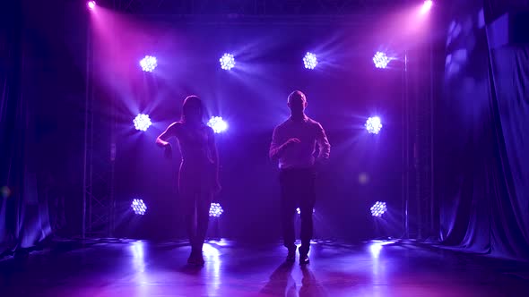 Young Couple Dancing Latin Music, Bachata, Merengue, Salsa, Shot in a Dark Studio with Neon Lights