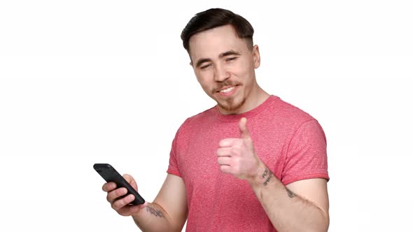 Portrait of European Man Having Beard and Mustache Expressing Surprise While Using Smartphone and