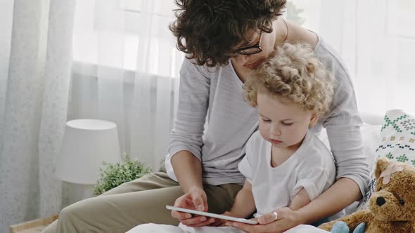 Mother and Baby Boy Watching Cartoons on Tablet