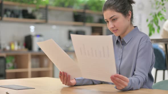 Young Indian Woman Reading Papers at Work