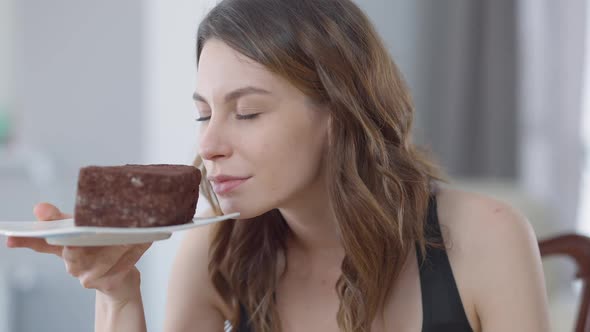 Charming Beautiful Slim Young Woman Smelling Delicious Sweet Cake on Plate Smiling Licking Lips