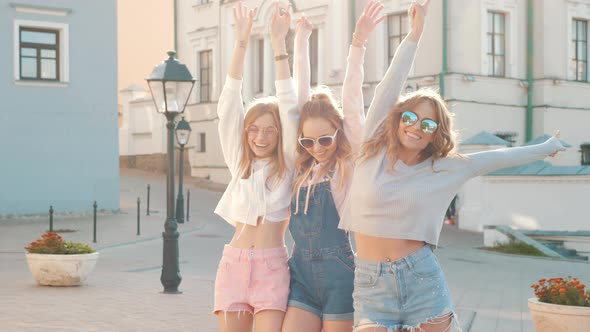 Three young female hipster friends posing outdoors