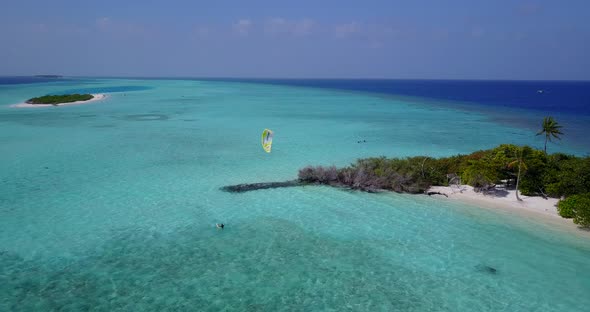 Tropical fly over travel shot of a white sand paradise beach and blue sea background in high resolut