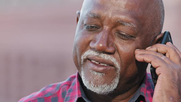Smiling Older Black Man Talking on Cellphone Closeup Happy Grandfather Chatting with Relatives or