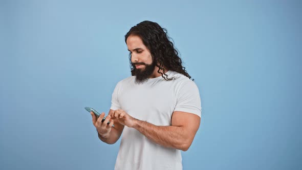 Bearded Man Networking on Smartphone Got Message About Winning and Feeling Excited Laughing Over