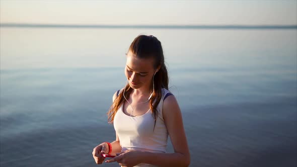 Young Happy Woman Listen to the Music Using a Headphones