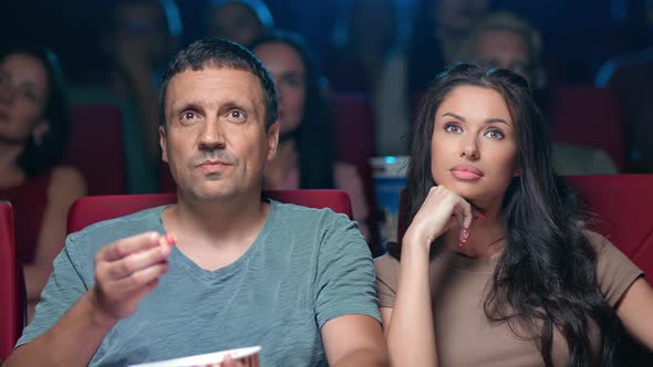 Astonishment Couple Watching Film at Cinema Eating Popcorn Surrounded By Crowd of Spectators