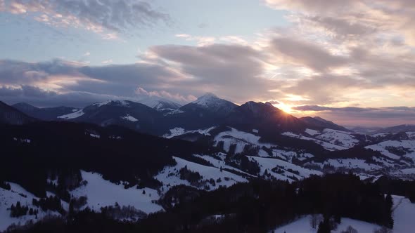 Aerial View Sunset Over Winter Mountain Trees Landscape Colored Clouds at Dusk