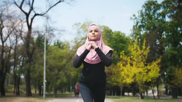 Young Fitness Muslim Woman Doing Sport Excercises Before Run in Park Slow Motion