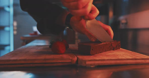 A professional chef is cutting ingredients for the dessert