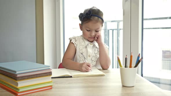 Little Elementary Schoolgirl Doing Homework. Cute Child Learns on His Own. Back To School.