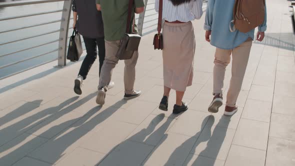 Back View of Asian Friends Walking along Embankment