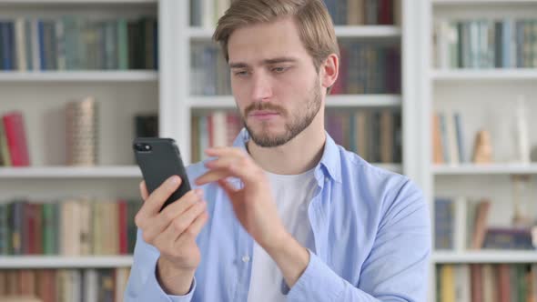 Portrait of Man Reacting to Loss on Smartphone