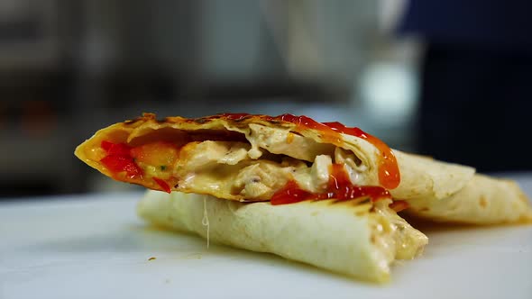 Tasty pita roll with vegetables and meat poured with red souce