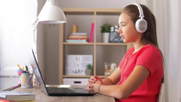 Girl in Headphones with Laptop Computer at Home