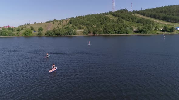 Aerial view of people Stand Up Paddling on pond in provincial city 23