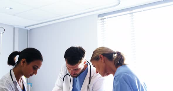 Team of doctors putting oxygen mask on a female senior patient face