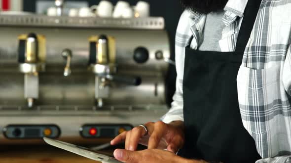 Waiter using digital tablet at counter