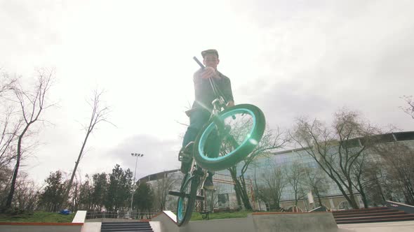 BMX Rider Doing Tricks in Cocncrete Skatepark