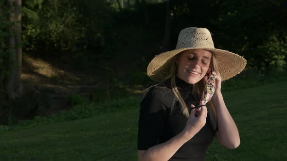 A medium shot of a beautiful young woman taking off her face mask outdoors