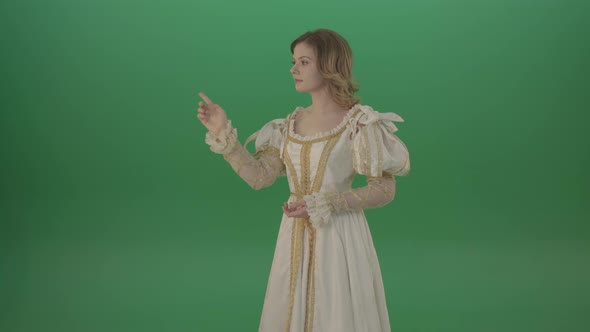 Satisfied Woman In A Medieval Dress Flips A Touchscreen And Smiles Isolated On Green Background